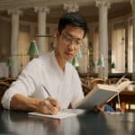 Un homme qui écrit sur une feuille